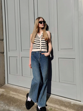 a lady wears a knitted vest with a loose fit jeans